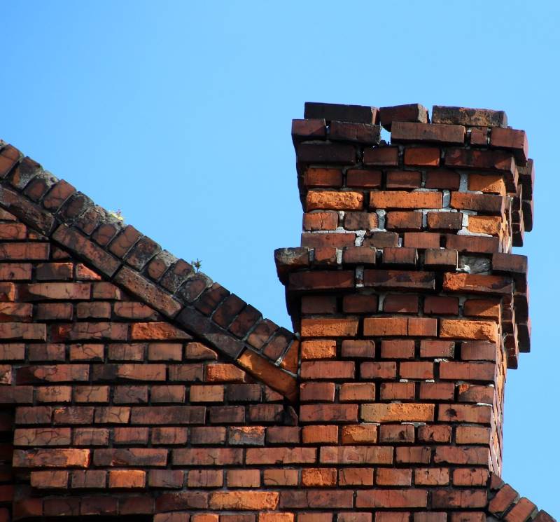 Damaged chimney on an Mckinney home showing cracks and missing mortar